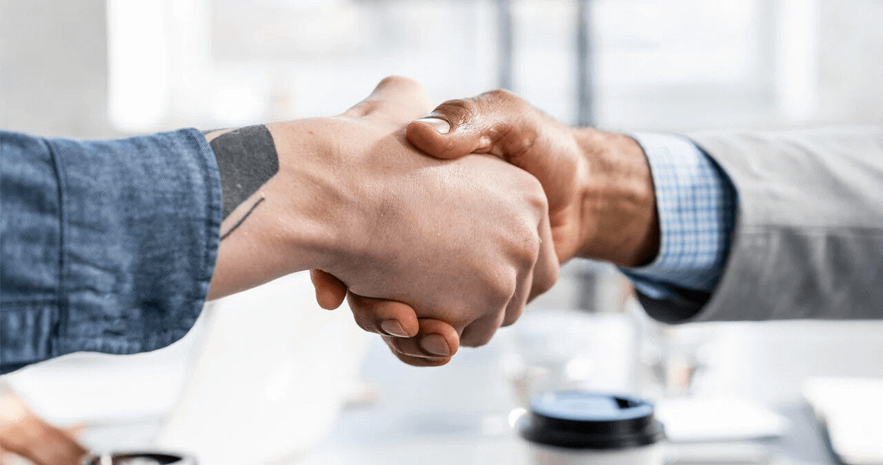 Duas mãos a cumprimentarem-se, simbolizando uma parceria de negócios de sucesso e confiança em copywriting.