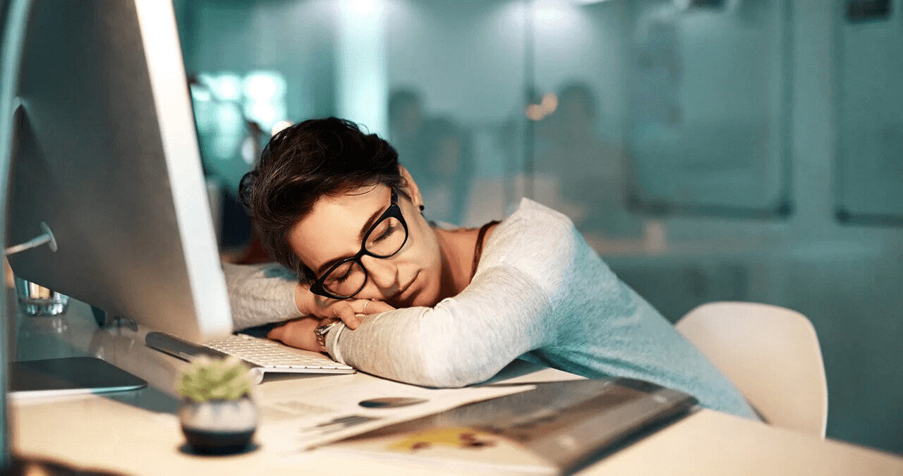 Copywriter a dormir sobre o teclado, simbolizando o esgotamento ou bloqueio criativo devido a erros comuns."